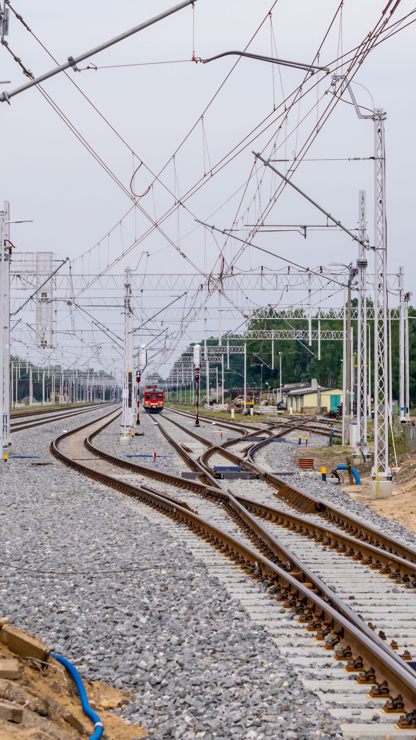 railroad tracks at a train station on a cloudy day